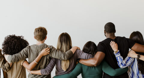 Rearview of diverse people hugging each other