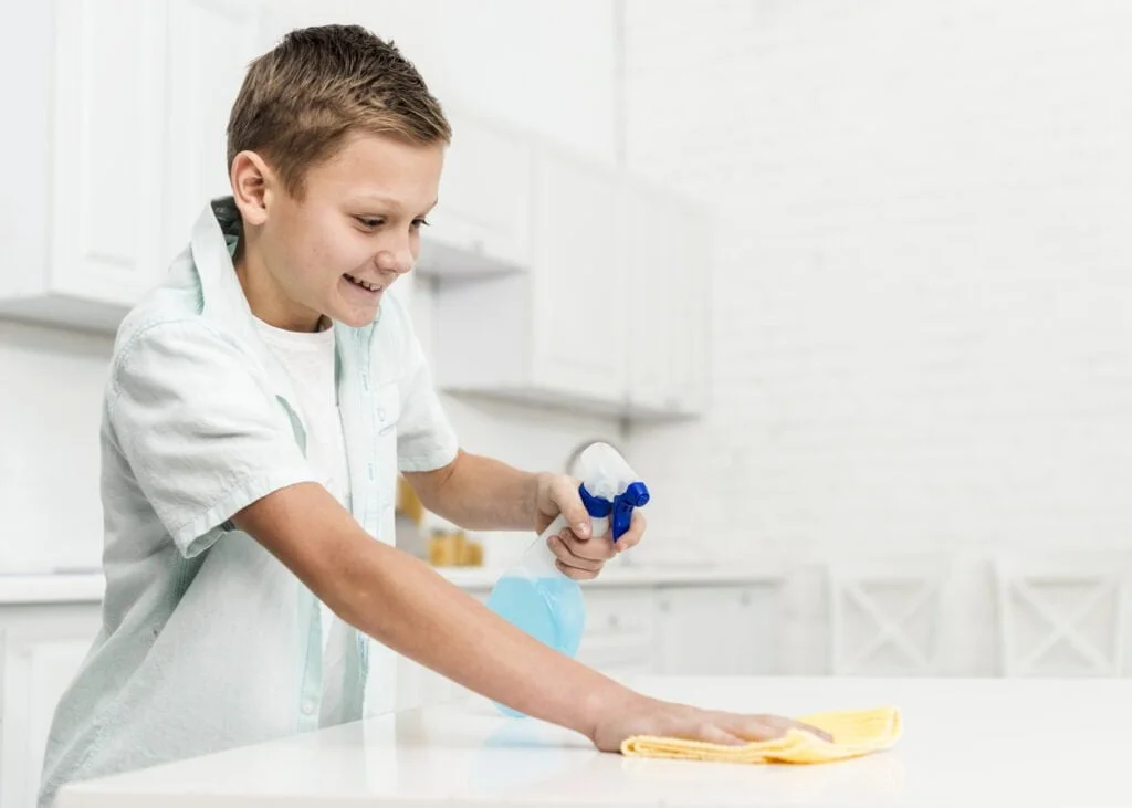 La importancia de la limpieza en las organizaciones 1 WorldBrain+ side view happy boy cleaning table with rag